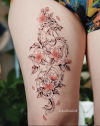 a woman with a dragon tattoo on her thigh